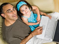 father and daughter sitting with laptop