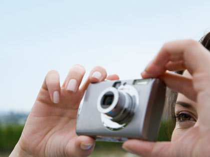 Mujer tomando una foto con un a cámara digital Mujer tomando una foto con un a cámara digital