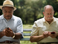 two men texting on their phones