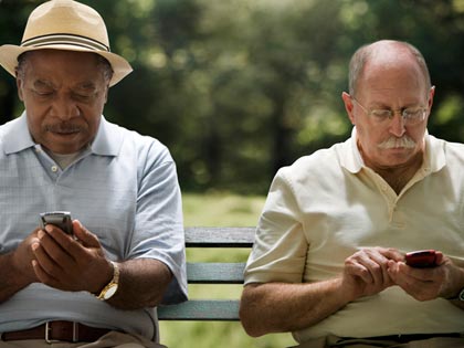 two men texting on their phones two men texting on their phones