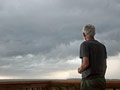 Hombre enfrente a un cielo nublado