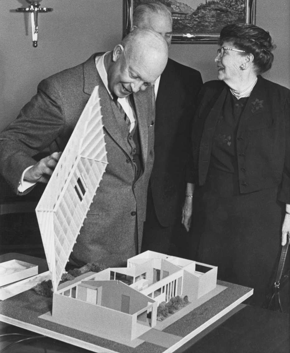 President Eisenhower examines a scale model of the "House of Freedom," with Dr. Andrus in the background.