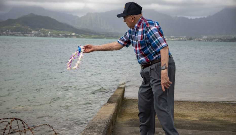 Hugh McNaughton throwing a flower wreath into the pacific ocean