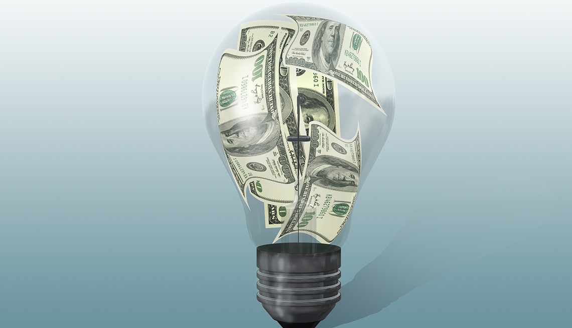A light bulb with money inside