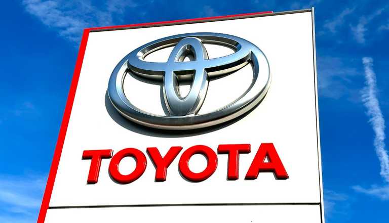 a toyota logo on a white sign against a blue sky