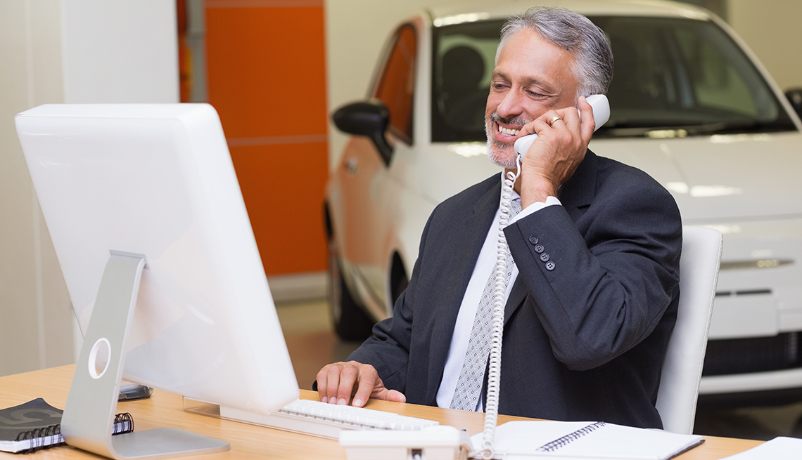 car salesman on the phone at a dealership