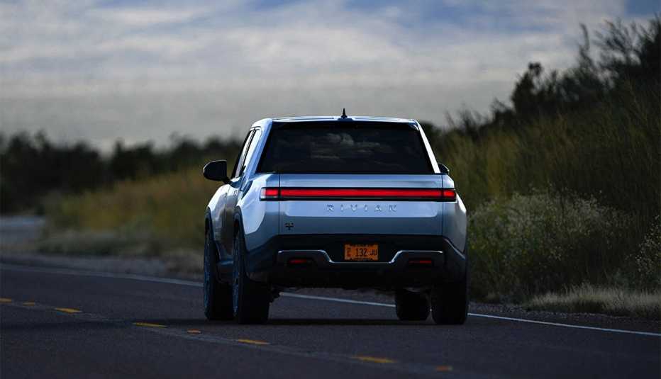 A Rivian R1T electric truck drives down a highway 