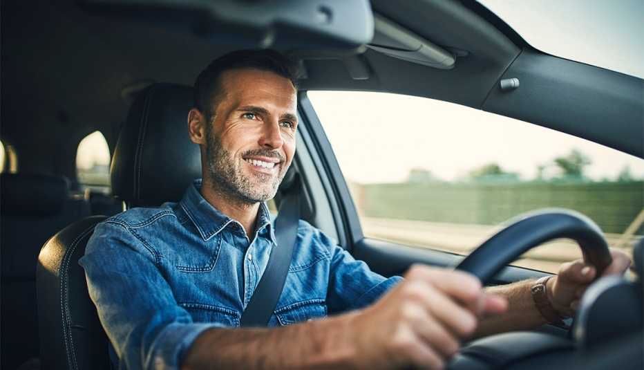 smiling man driving a car