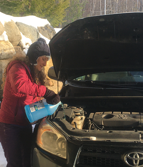 woman adding engine fluid to her Toyota