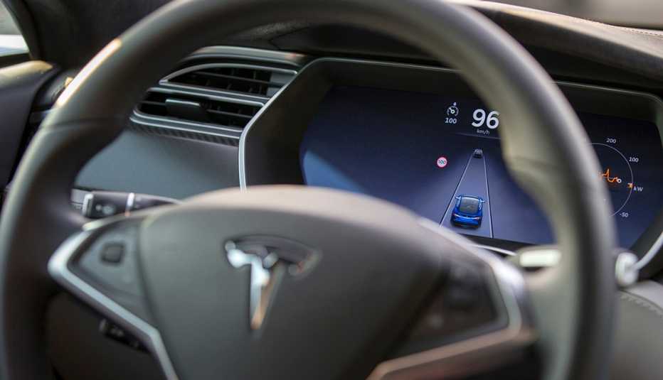a steering wheel emblazoned with the tesla logo over a dashboard