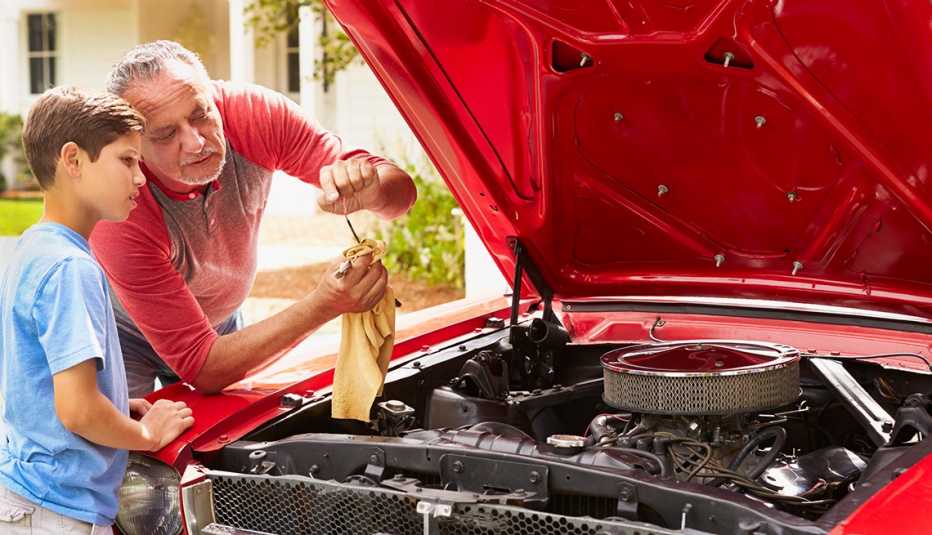 Dad showing son how to check car oil