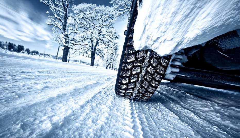 a closeup low angle view of a car tire while driving on snow