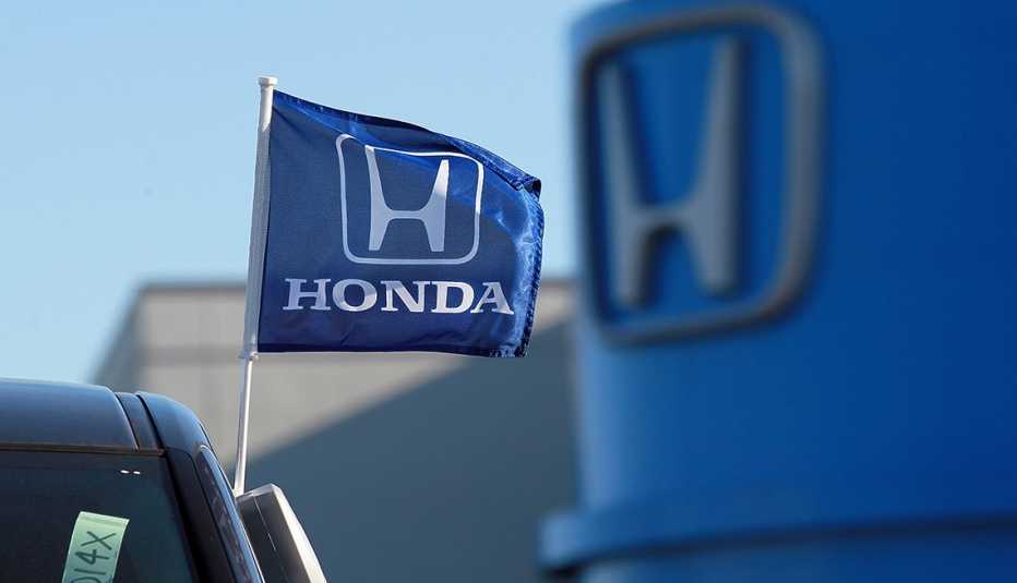 a blue honda flag flies from a vehicle outside a honda dealership