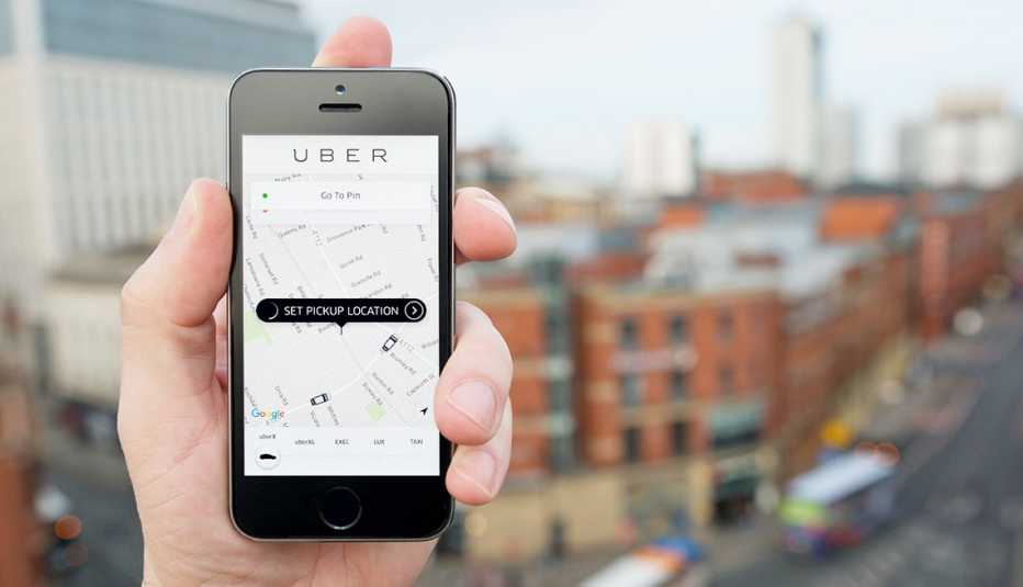 A hand holds phone with uber app open