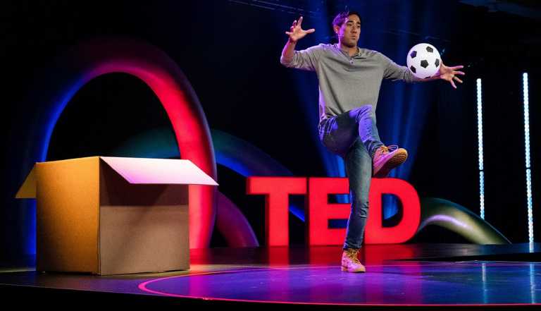Zach King on stage kicking soccer ball in front of TED sign
