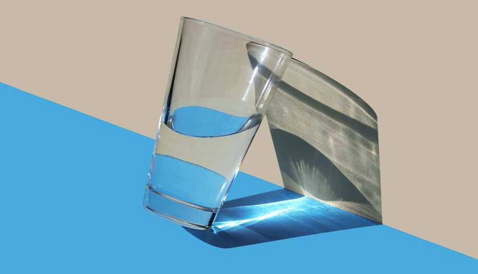 half glass of water against a wall