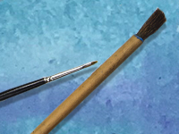 Thin and thick paintbrushes on blue background