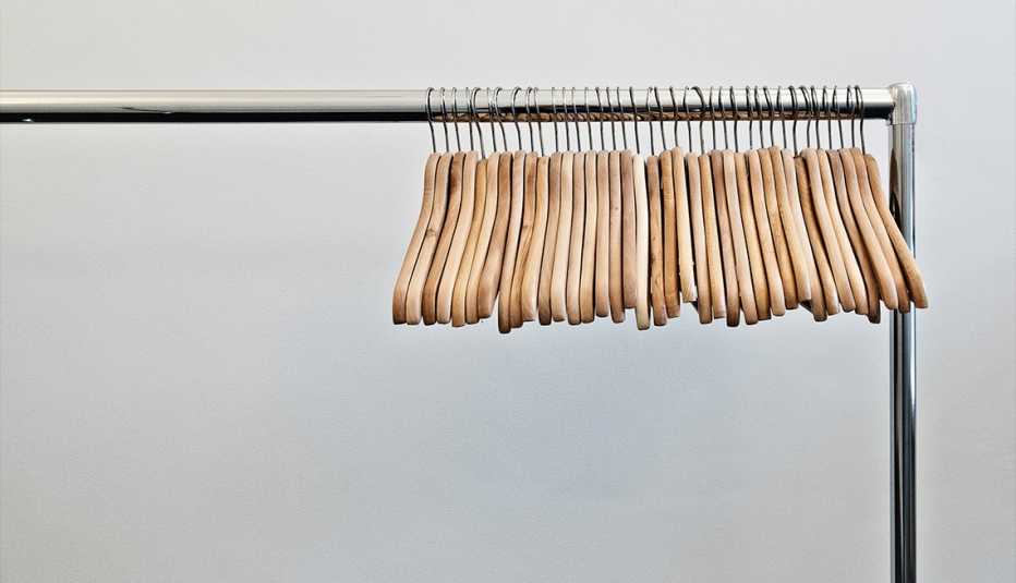 empty wooden hangers on a metal rack