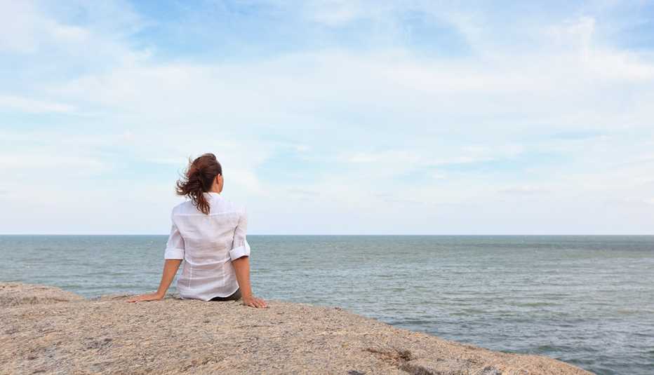 woman sitting on a rock looking out over the ocean