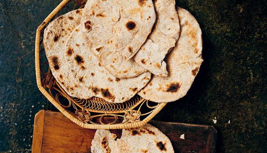 Chapati — Whole-Wheat Bread on a woven basket and a cutting board