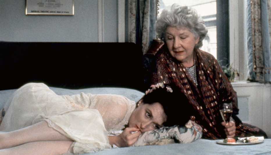 Meryl Streep as Rachel Samstat curled up on a bed beside a seated Maureen Stapleton playing Vera in movie still from Heartburn