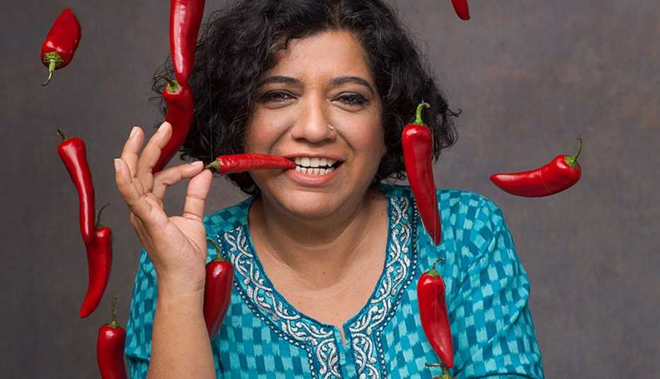 Chef Asma Khan poses with several red peppers.