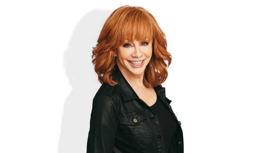 reba mcentire smiling in front of white background