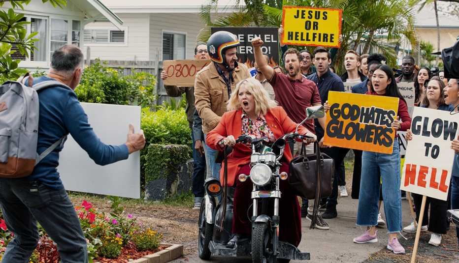 Ben Falcone and Melissa McCarthy ride a motorcycle in the Netflix show “God’s Favorite Idiot.”
