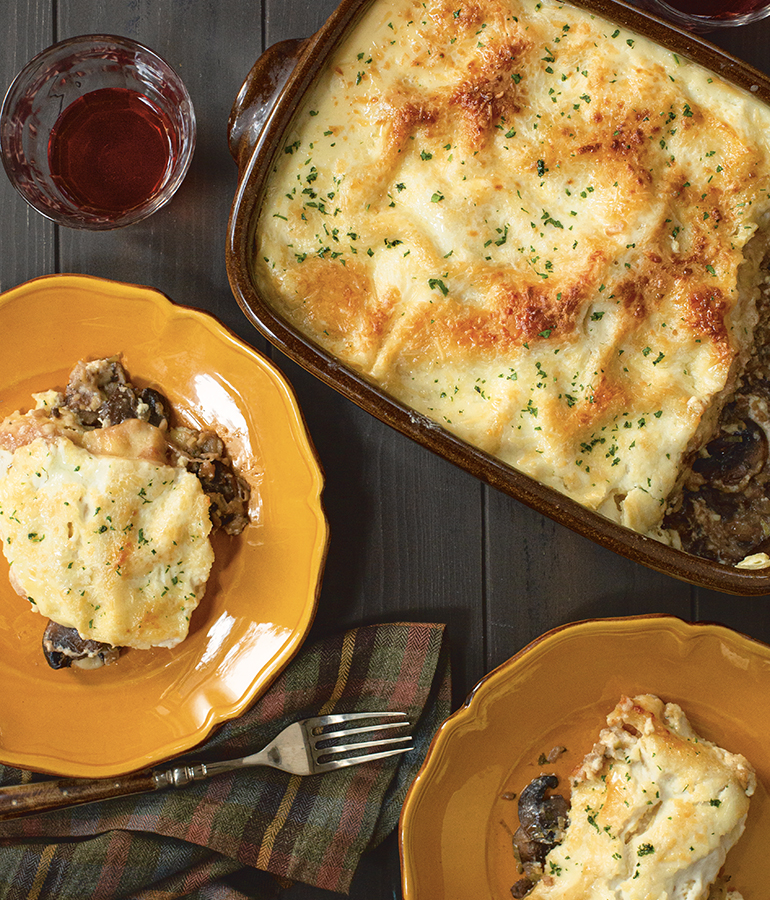 Mushroom-Ricotta Lasagne with Port Sauce displayed on plates in a casserole dish