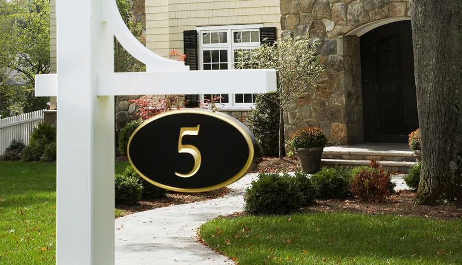number five sign hanging in front of a house in chatham new jersey; house has stone and yellow siding