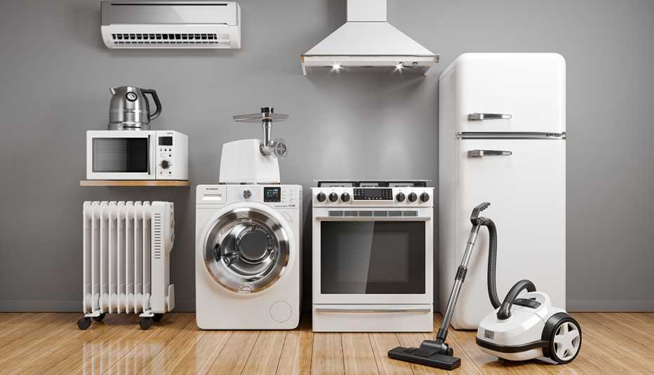 a grouping of white appliances including refrigerator, oven, washing machine, microwave, vacuum, electric tea kettle, radiator