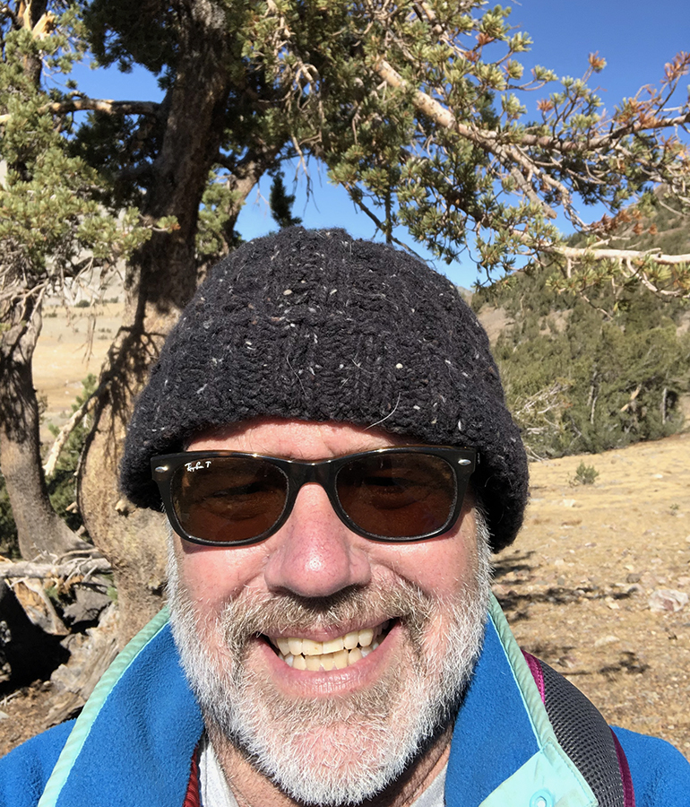 Peter Fish smiles for a selfie in front of trees at Yosemite National Park