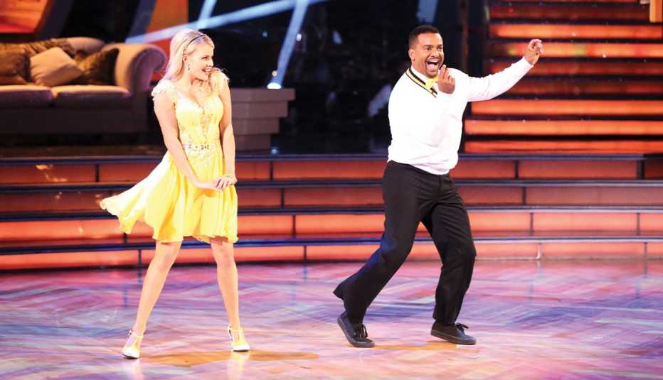 alfonso ribeiro onstage dancing with a woman in a yellow dress in a still from dancing with the stars