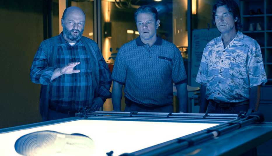 matthew maher as peter moore, matt damon as sonny vaccaro and jason bateman as rob
strasser standing behind table with shoe on it in a still from air