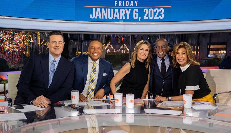carson daly, craig melvin, savannah guthrie, al roker, and hoda kotb at anchor desk with papers and today show cups