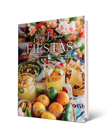book cover with words muy bueno, fiestas, 100 plus delicious mexican recipes for celebrating the year, by yvette marquez-sharpnack; flowers, margaritas, tortilla chips, oranges and limes on cover