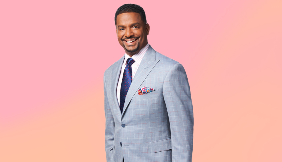 alfonso ribeiro wearing a gray suit and smiling against a light pink and orange background