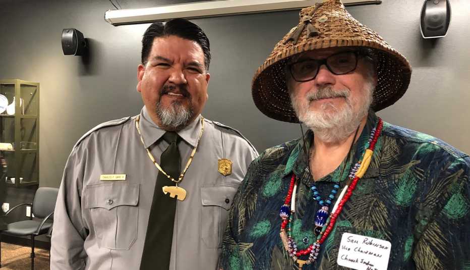 chuck sams in a national park service uniform posing for a photo with a man inside the visitor center