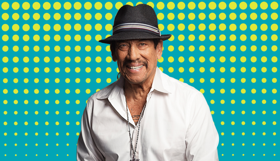 danny trejo wearing bucket hat against teal background with yellow circles on it
