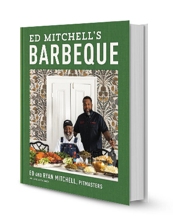 ed and ryan mitchell behind table with a bunch of food on book cover that says ed mitchell's barbecue; ed and ryan mitchell, pitmasters with zella palmer