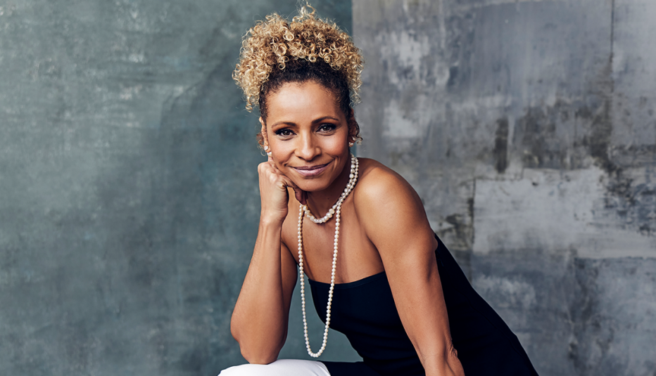 michelle hurd leaning face on hand; gray background