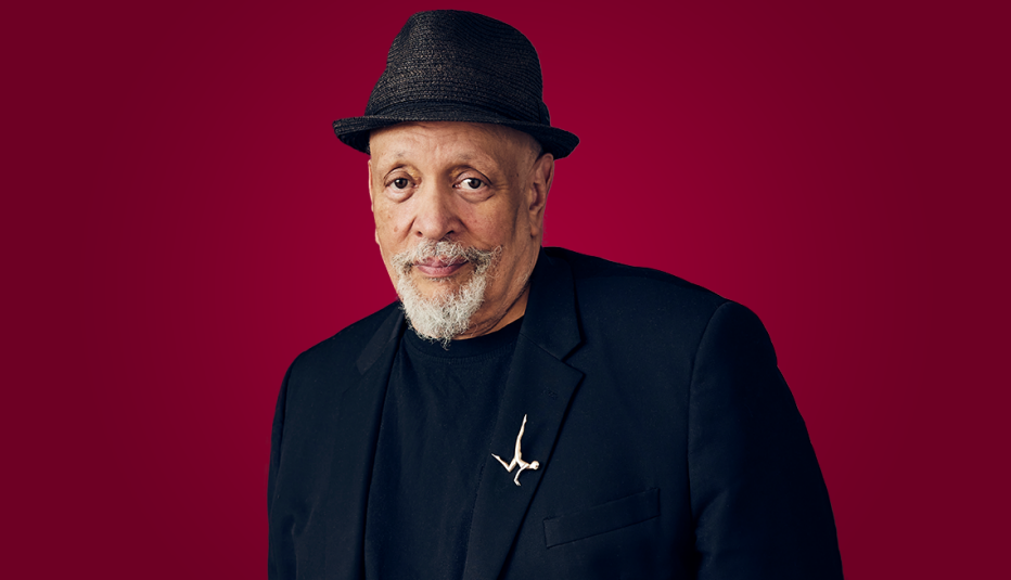 walter mosley wearing black suit jacket and black hat against red background