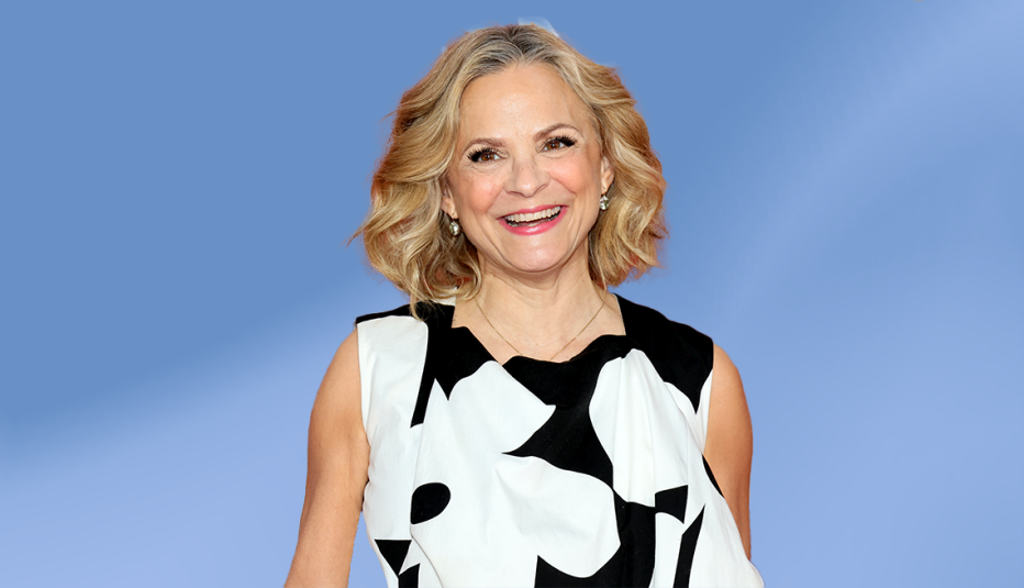amy sedaris in black and white outfit against blue background