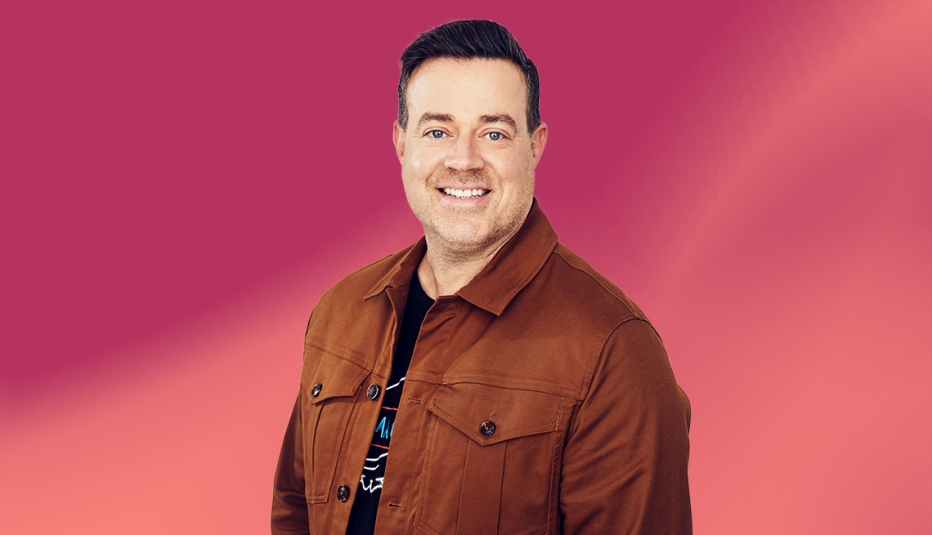 carson daly wearing brown jacket against pink ombre background