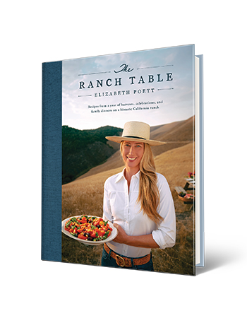 book cover with words the ranch table, recipes from a year of harvests, celebrations, and family dinners on a historic california ranch, elizabeth poett; woman holding plate of food on cover