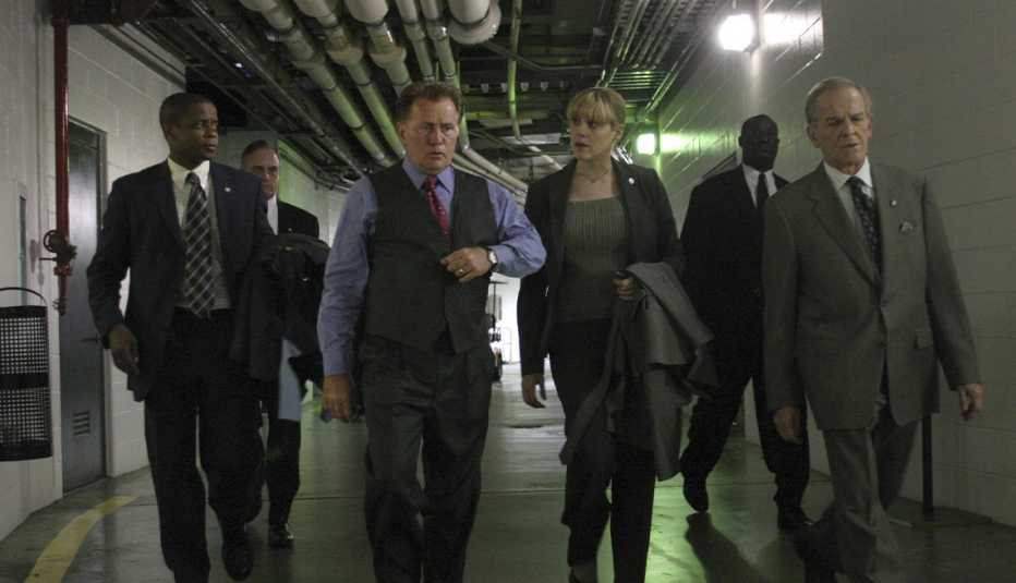 dule hill as charlie young, martin sheen as president josiah "jed" bartlet, mary mccormack as kate harper, john spencer as leo mcgarry walking in hallway a in still from the west wing