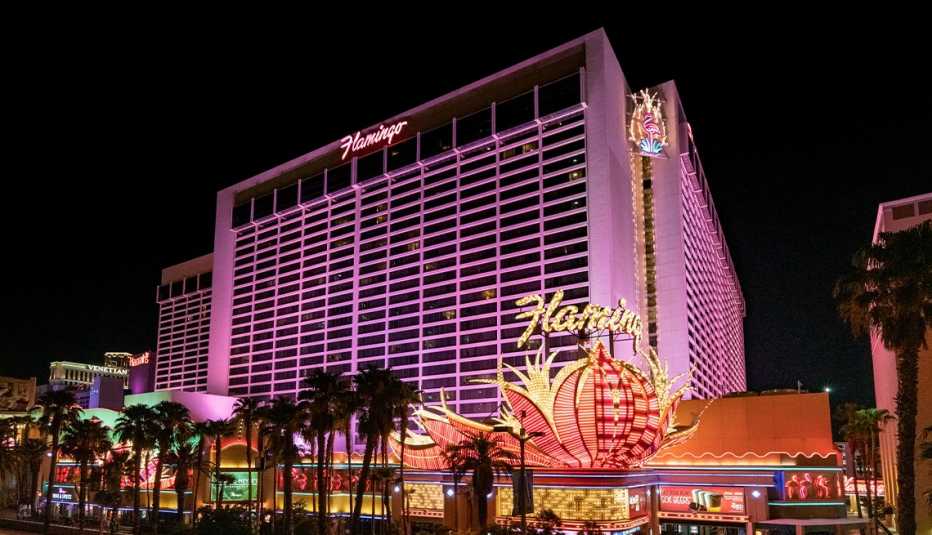 the flamingo las vegas hotel and casino at night with palm trees in front of it