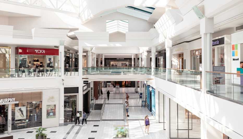 two-level shopping mall with white ceiling and white floor with black and gray squares; people walking