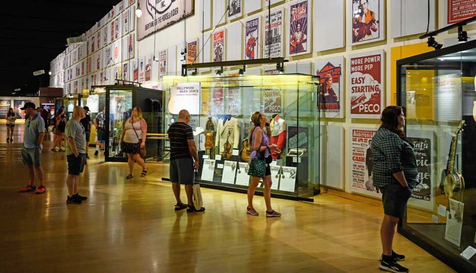 people standing, looking at items on wall and in glass cases