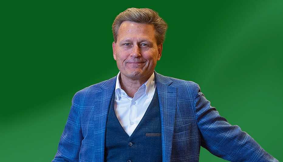 david baldacci in blue suit against green background